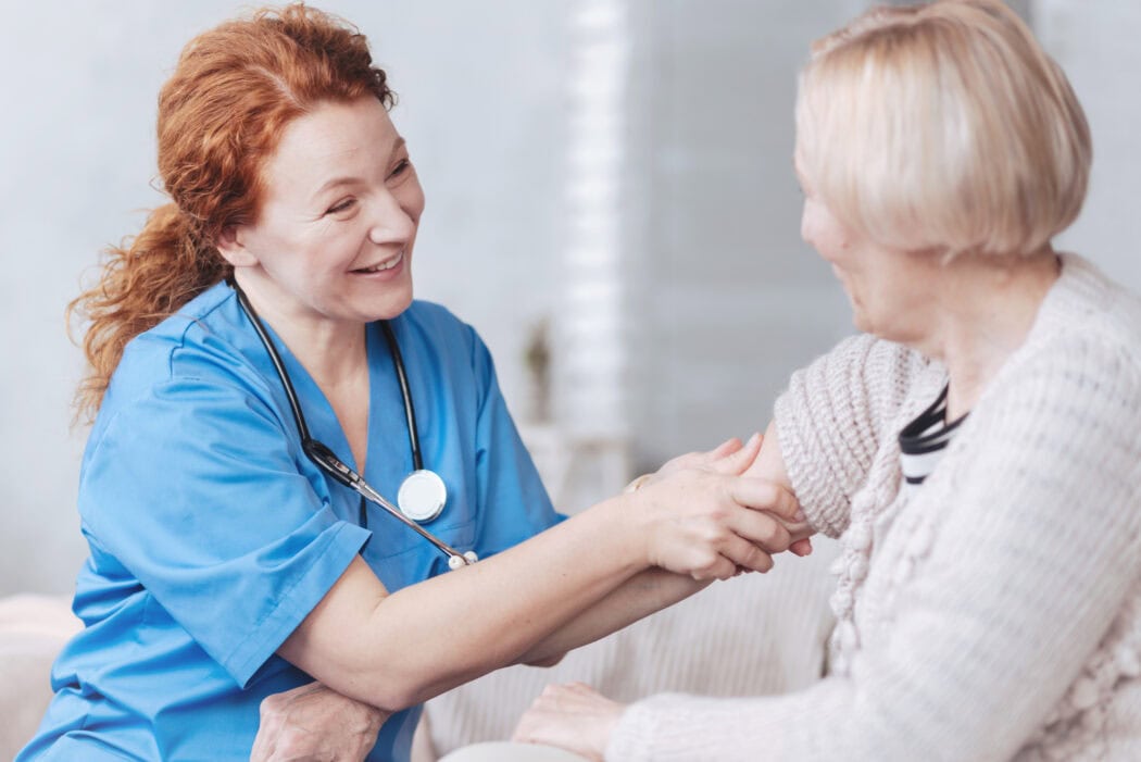 Positive minded nurse taking care of elderly woman