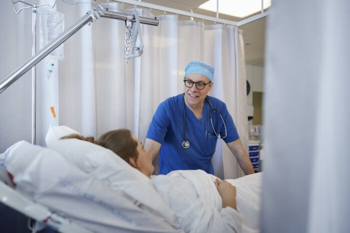 Smiling doctor checking on patient